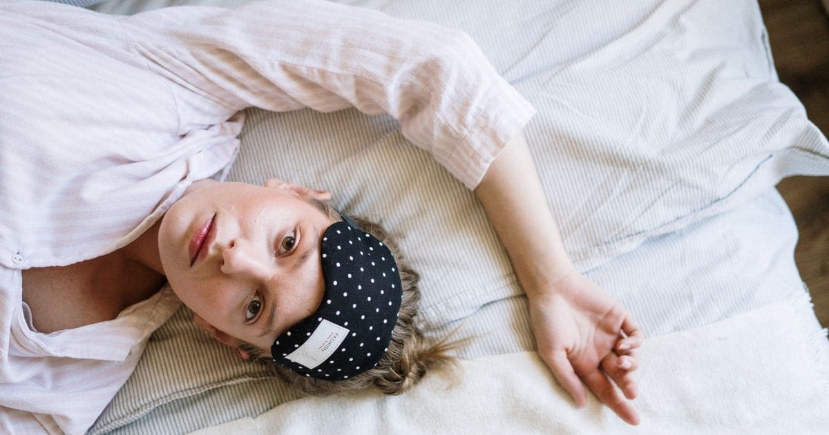 ragazza con occhi spalancati sul letto perché lo stress non fa dormire