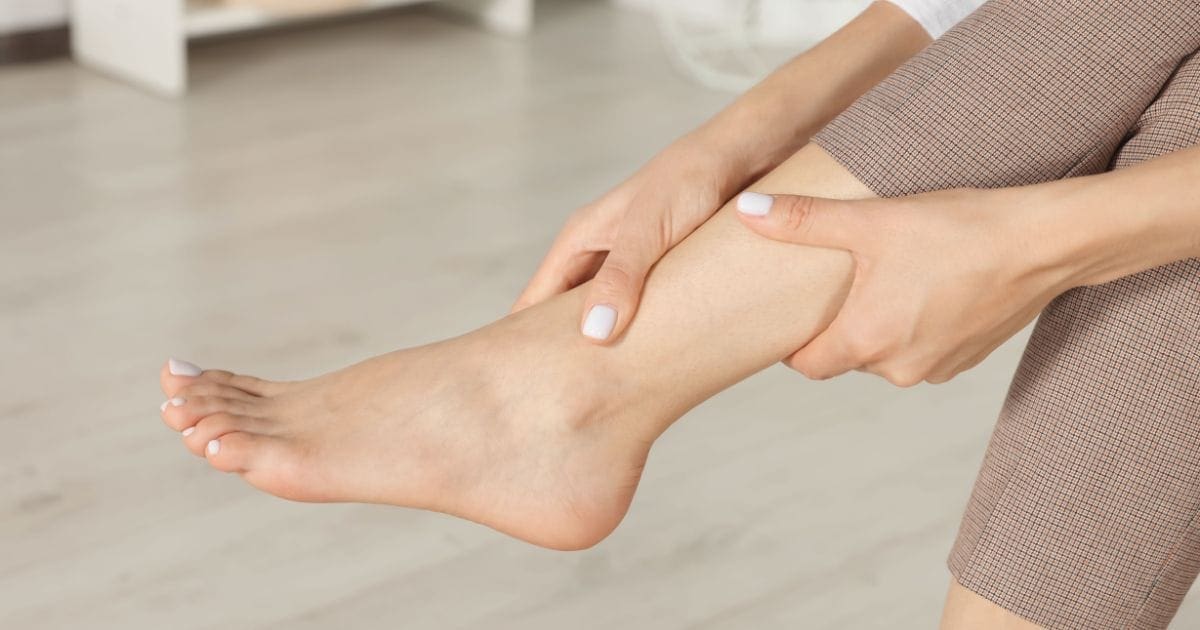 donna tiene in mano una caviglia sgonfia dopo avere capito le cause dell'edema e risolto